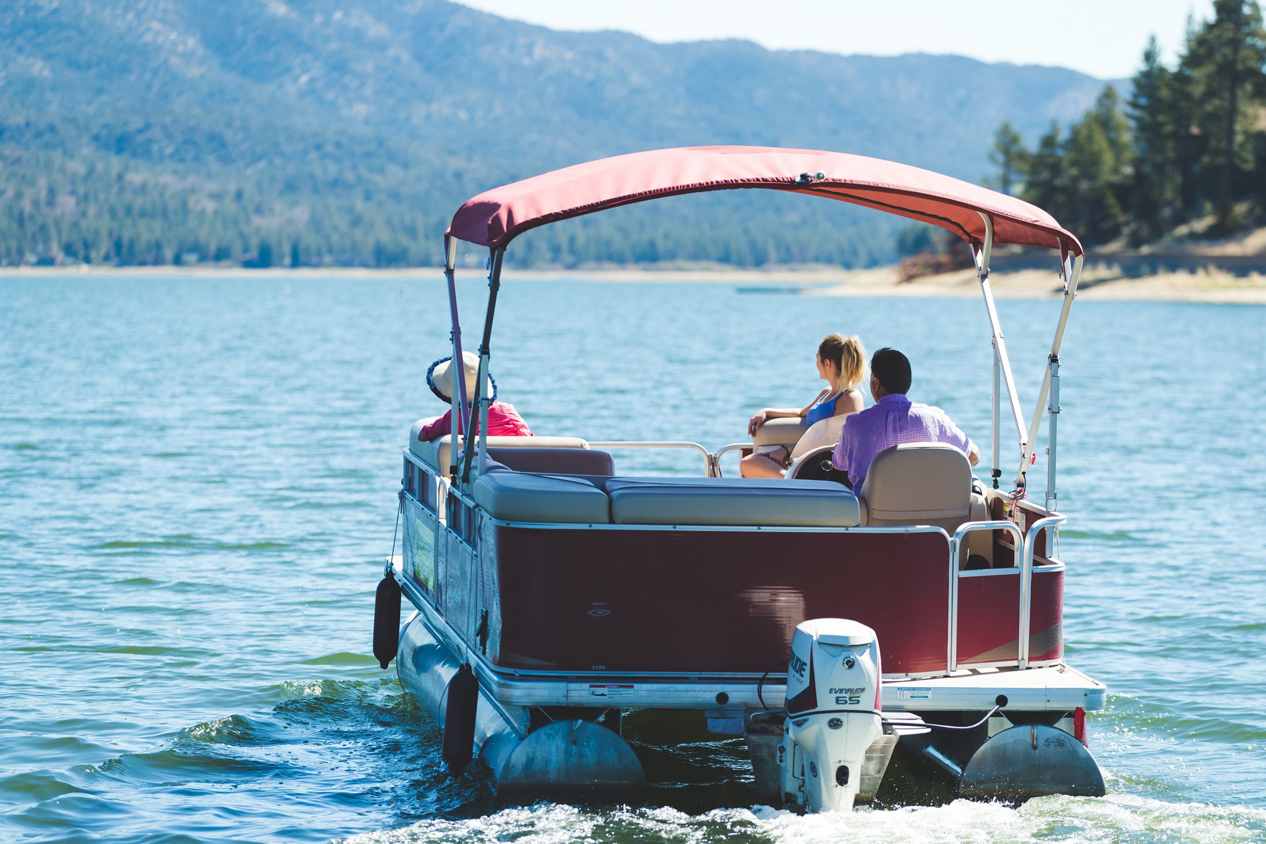 Family enjoys pontoon boat rental on Big Bear Lake with vacation cabin at Big Bear Lakefront Cabins